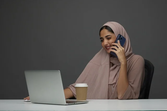 Saudi Businesswoman with Laptop and Phone at Office