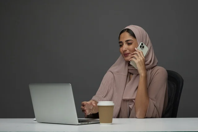 سيدة أعمال سعودية تجري مكالمة مع لابتوب في المكتب سيدة أعمال سعودية تجري مكالمة مع لابتوب في المكتب