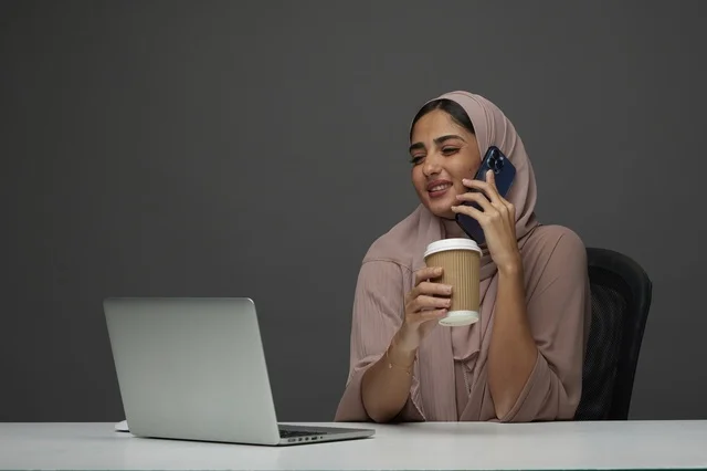 Saudi Businesswoman with Laptop and Coffee in Office