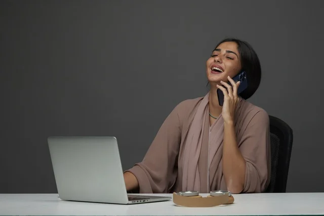 Saudi Businesswoman Making Phone Call at Office Desk