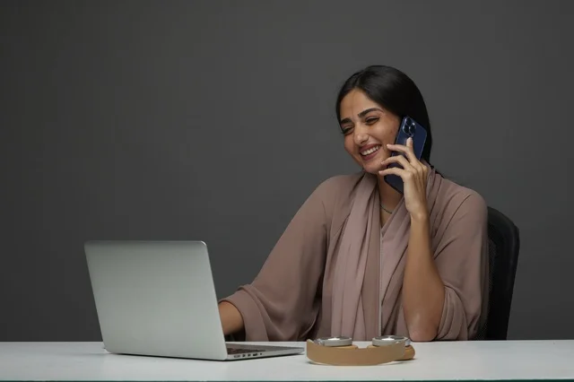 سيدة أعمال سعودية مع لابتوب وهاتف ذكي في المكتب سيدة أعمال سعودية مع لابتوب وهاتف ذكي في المكتب