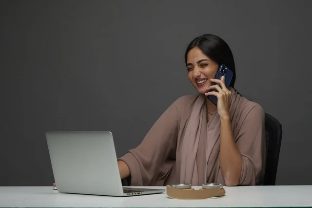 سيدة أعمال سعودية تجري مكالمة هاتفية مع لابتوب