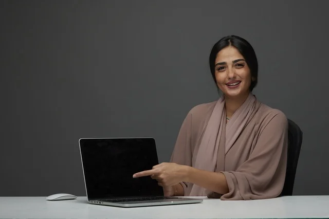 Saudi Woman Pointing at Laptop Screen in Studio