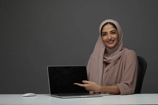 سيدة أعمال سعودية تشير إلى شاشة لابتوب في استوديو