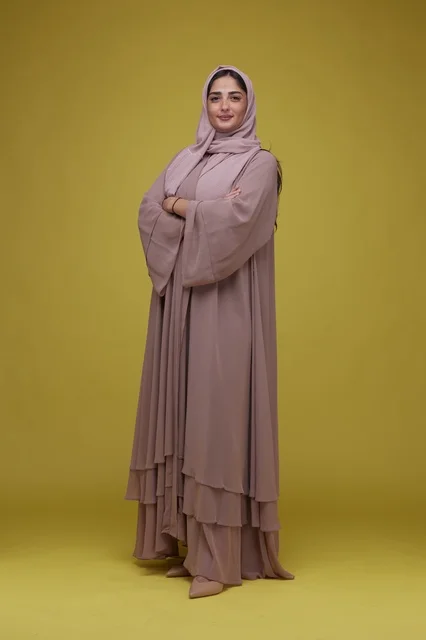 Saudi Woman in Pink Abaya Standing on Yellow Background