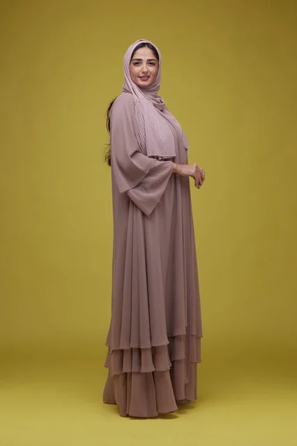 Saudi Woman in Mauve Abaya on Solid Yellow Background