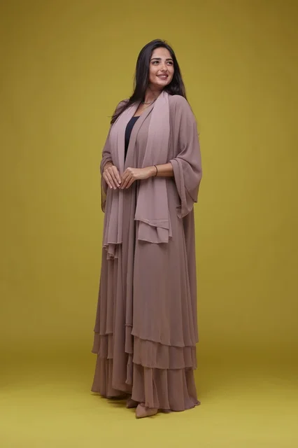 Saudi Woman in Rose Abaya on Yellow Studio Background