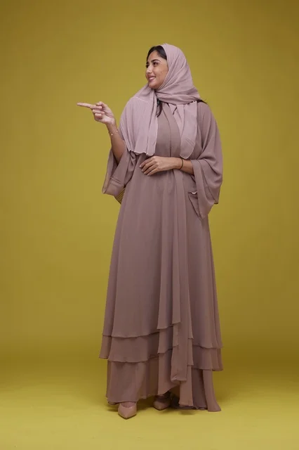 Saudi Woman Pointing on Yellow Background