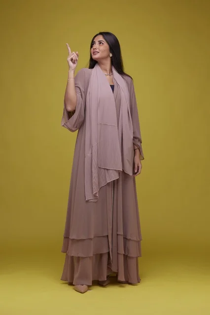 Saudi Woman in Abaya Pointing Up on Yellow Background