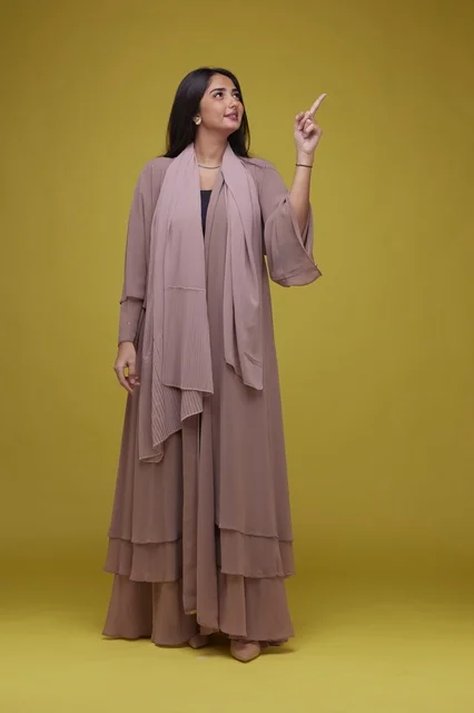 Saudi Woman Pointing Upwards on Yellow Background