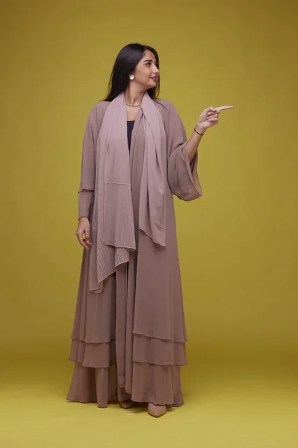 Saudi Woman in Abaya Pointing on Yellow Background