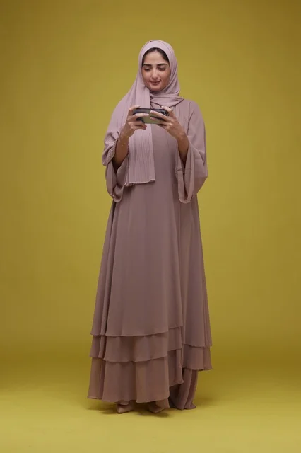 Saudi Woman Using Smartphone on Yellow Background