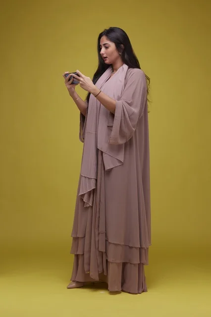 Young Saudi Woman Playing Game on Smartphone