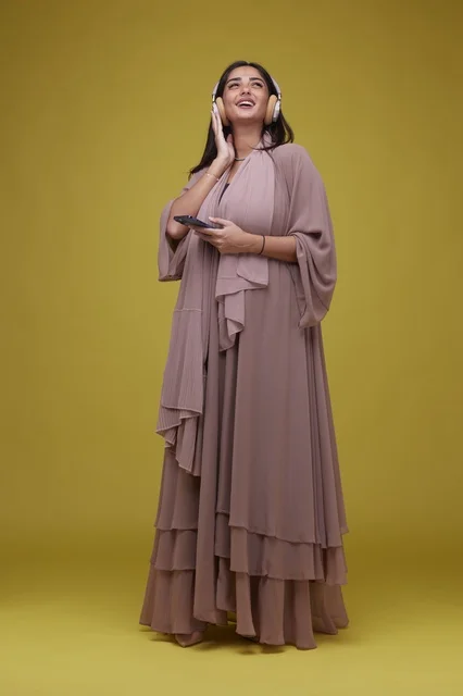 Saudi Woman with Headphones and Smartphone on Yellow