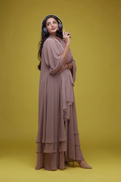 Young Saudi Woman Listening with Headphones and Smartphone