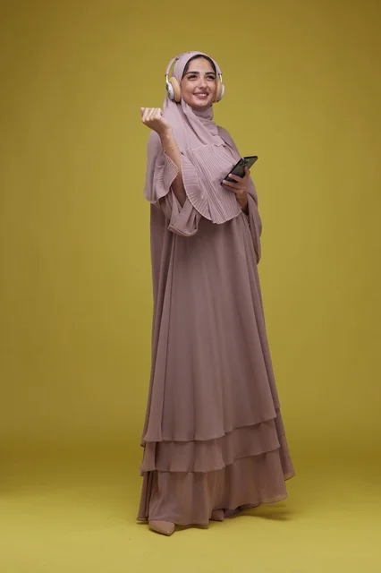 Saudi Woman with Headphones and Smartphone Yellow Background