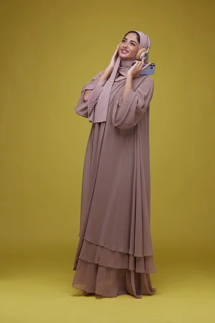 امرأة سعودية تستمع للموسيقى بالهاتف خلفية صفراء