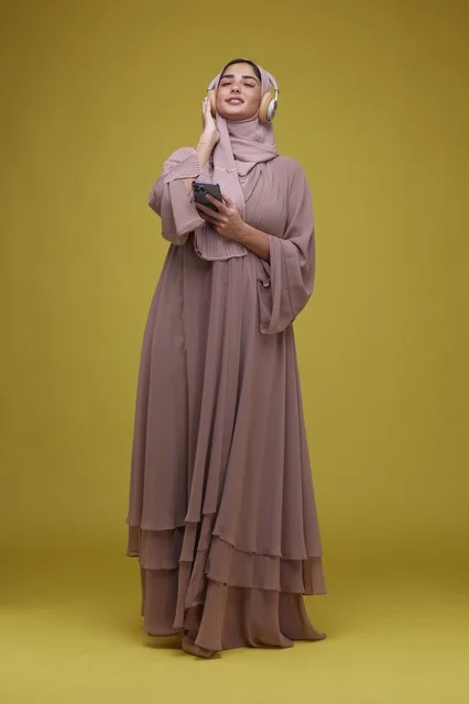 Saudi Woman Listening to Music on Smartphone in Studio