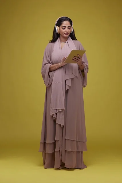 Saudi Woman with Tablet and Headphones on Yellow