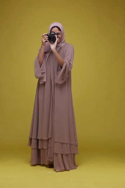 Saudi Woman Photographer Using Camera on Yellow Background