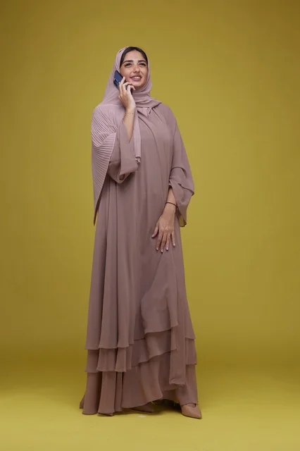Saudi Woman Talking on Smartphone with Yellow Background