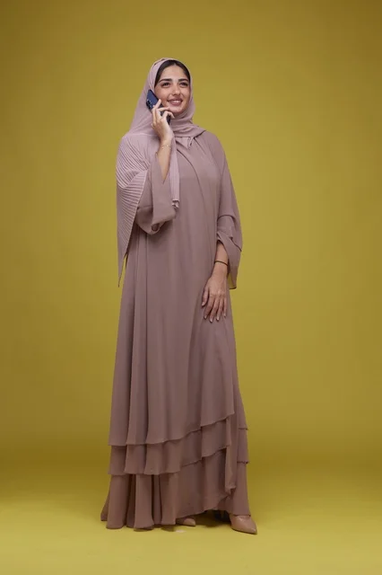 Saudi Woman Talking on Smartphone wearing Beige Abaya