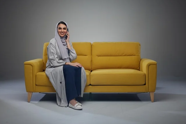امرأة سعودية تجلس على أريكة تتحدث بالهاتف