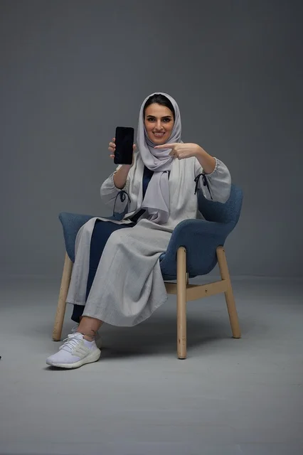 Saudi Woman Sitting with Smartphone in Studio