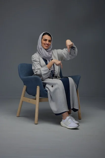 Saudi Woman in Abaya Pointing Down in Studio