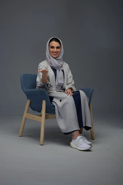 Saudi Woman in Grey Abaya Sitting in Blue Armchair