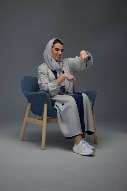امرأة سعودية تجلس وتشير إلى الأسفل في الاستوديو