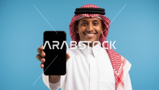 رجل سعودي يمسك هاتف ذكي بشاشة فارغة