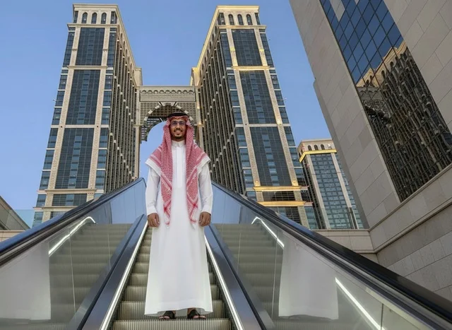 Saudi Man in Traditional Thobe on City Escalator