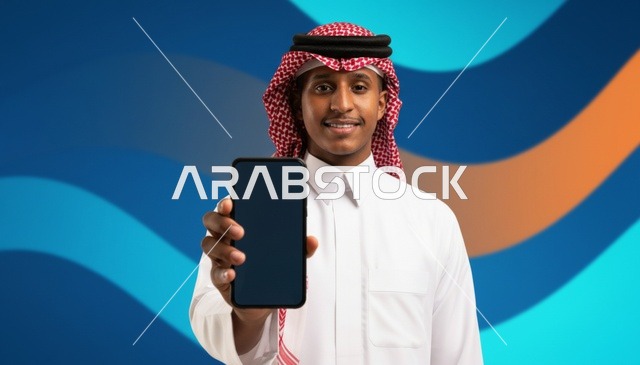 رجل سعودي يحمل هاتفاً ذكياً بشاشة فارغة