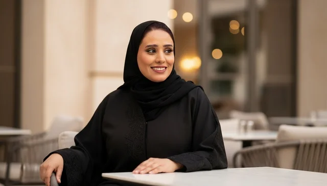 امرأة سعودية بعباءة سوداء تتحدث في مقهى