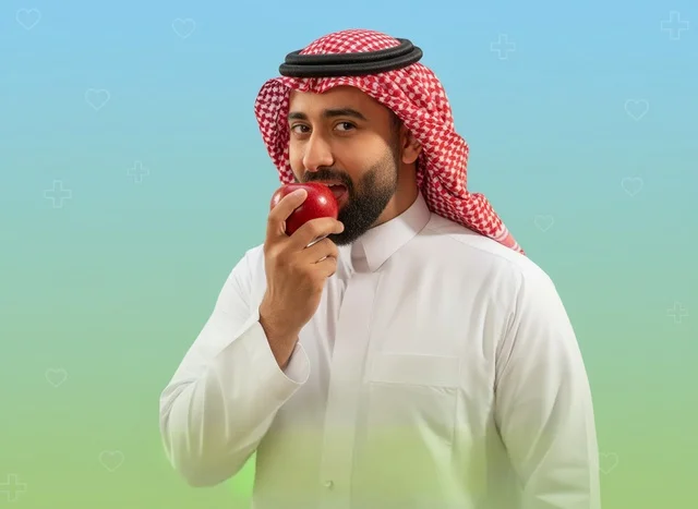 Saudi Man in Traditional Dress Eating a Red Apple Saudi Man in Traditional Dress Eating a Red Apple
