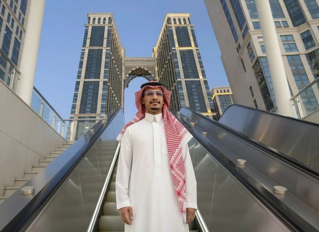 Saudi Man in Traditional Attire at Makkah Skyscrapers