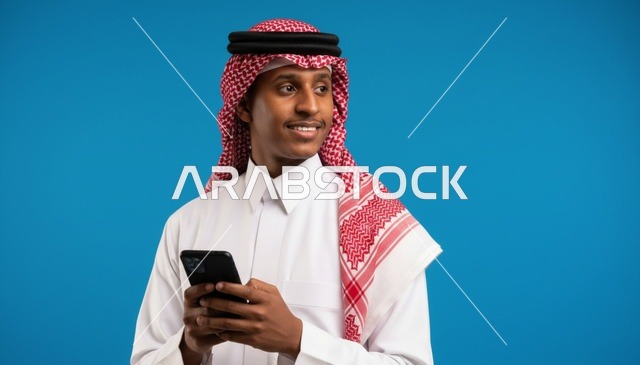 رجل سعودي يحمل هاتف ذكي بخلفية زرقاء