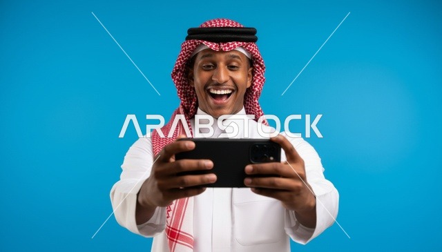 Saudi Man Using Smartphone on Blue Background