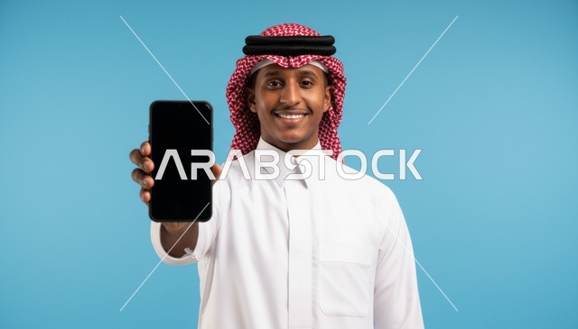 رجل سعودي يمسك هاتف ذكي بشاشة فارغة