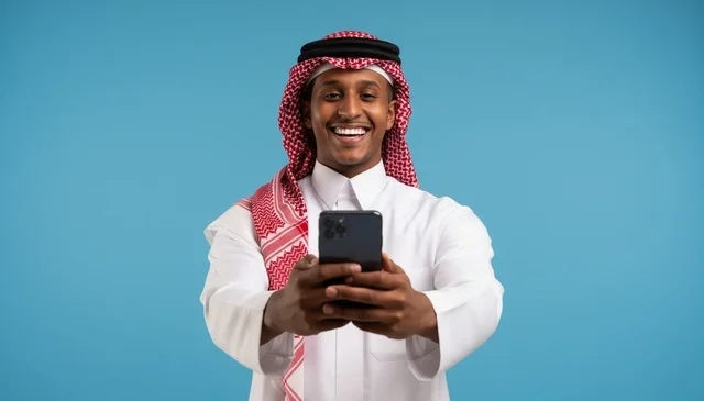 رجل سعودي مبتسم يستخدم الهاتف الذكي