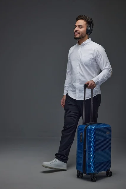 Saudi Man Walking with Suitcase and Headphones