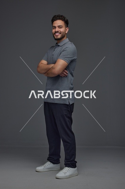 رجل سعودي يقف بوضعية ثني الذراعين في الاستوديو