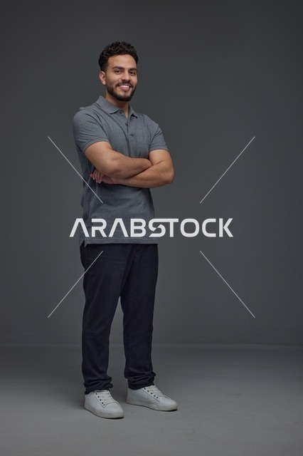 رجل سعودي يقف بذراعين متقاطعين في استوديو
