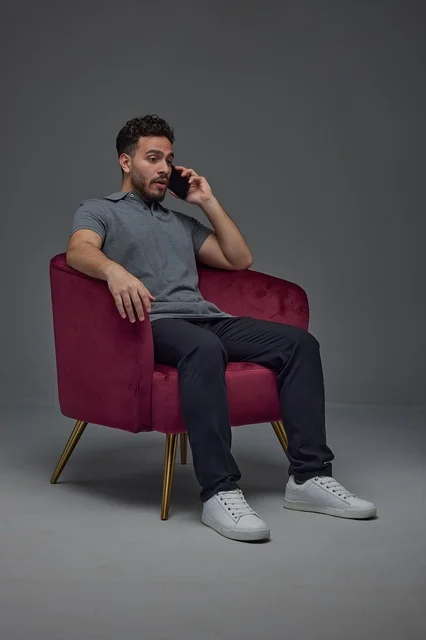 Saudi Man Sitting in Armchair Using Smartphone