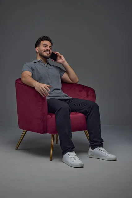 Saudi Man Sitting in Armchair Talking on Smartphone