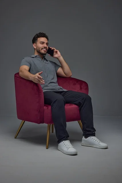 Saudi Man on Smartphone Sitting in Armchair