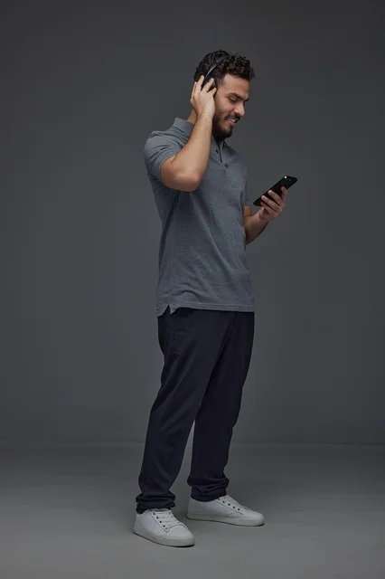 Saudi Man Using Smartphone and Headphones in Studio