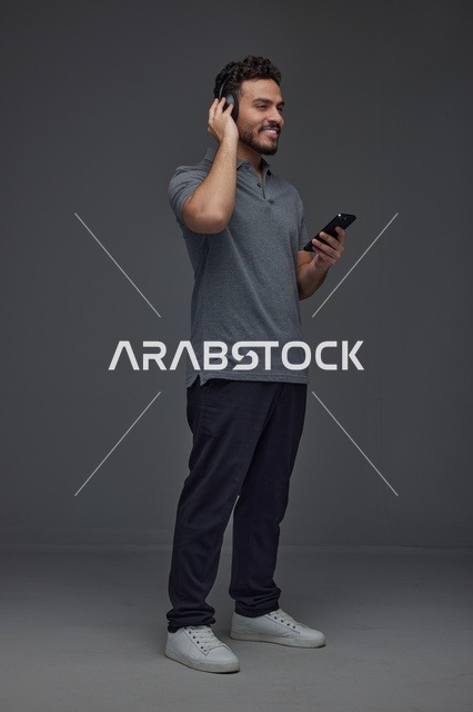 Saudi Man Using Smartphone with Headphones