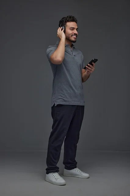 Saudi Man Using Smartphone with Headphones Saudi Man Using Smartphone with Headphones